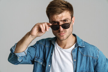 Portrait of confident man in sunglasses posing and looking at camera