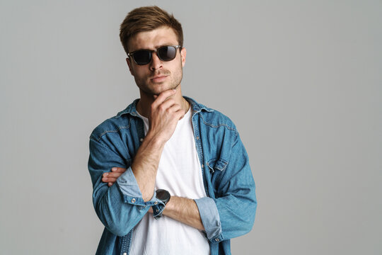 Portrait of confident man in sunglasses posing and looking at camera