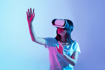 Virtual game of new generation. Girl in glasses examining something and raises hands