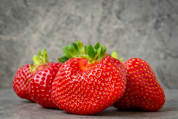 Pile of strawberries on a grey stone background