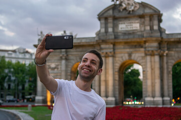 Madrid, Spain / July 13 2020 / Photo of an attractive guy next to Alcala gate in Madrid during sunset	
