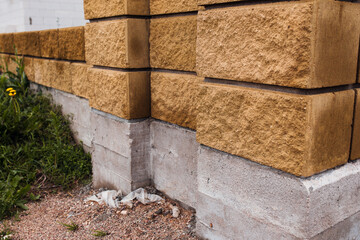 Stone blocks of a fence on a concrete strip foundation - supports for a wooden board fence