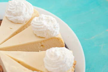 portion of cheesecake with jam on a white plate with cream