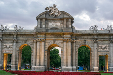 Obraz premium Madrid, Spain / July 13 2020 / Photo of an attractive guy next to Alcala gate in Madrid during sunset 