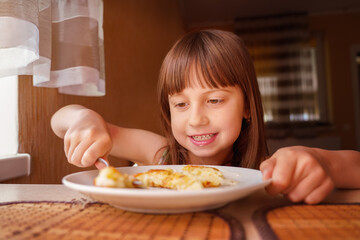 Beautiful girl eating cheesecakes for breakfast. Horizontal image.