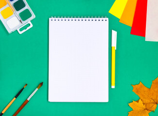 Office supplies on a green background. Back to school concept. Display of products for creativity and learning.Text frame with school supplies. The layout of the school. Flat lay. copy space.