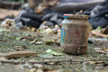 dirty glass jar among the garbage
