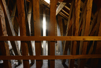 Historical house attic with wooden pole construction