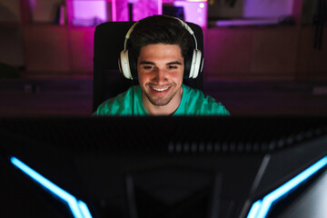 Image of caucasian happy man playing video game on computer