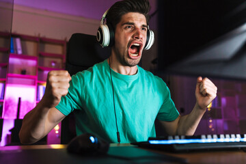 Image of excited man making winner gesture while playing video game