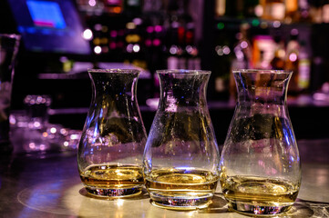 Flight of Scottish whisky, tasting glasses with variety of single malts or blended whiskey spirits on distillery tour in pub in Scotland