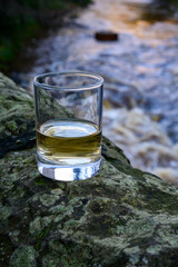 Scotch single malts or blended whisky spirits in glasses with water of river Spey on background, Scotland