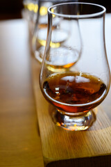 Flight of Scottish whisky, tasting glasses with variety of single malts or blended whiskey spirits on distillery tour in Scotland