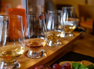 Flight of Scottish whisky, tasting glasses with variety of single malts or blended whiskey spirits on distillery tour in Scotland