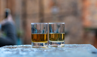 Scotch single malts or blended whisky spirits in glasses with old houses of Edinburgh on background, Scotland, UK