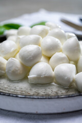 Fototapeta na wymiar Italian food, fresh fresh green basil and white mini mozzarella soft balls cheese