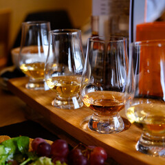 Flight of Scottish whisky, tasting glasses with variety of single malts or blended whiskey spirits on distillery tour in Scotland