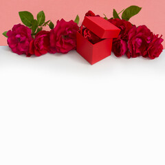 red roses and gift box on white background. postcard