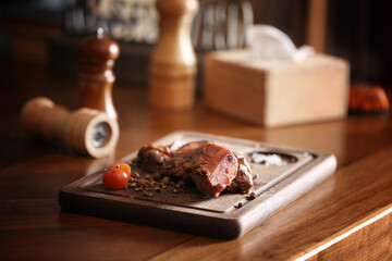 Tasty roasted meat served on wooden table. Cooking food