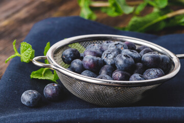 Bowl of fresh blueberry on kitchen table close up