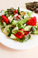 Salad With Fresh Vegetables: cucumbers, tomatoes, salad, pepper and basil. 