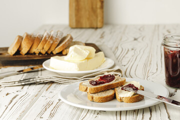 Slice of fresh bread with butter and jam on table