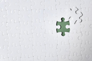 Blank white puzzle with separated piece on grey background, top view. Space for text