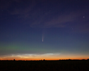 Wide angle shot of the prairie sky in the early morning, with the comet NEOWISE at the center, a faint aurora and some noctilucent clouds in the background © Salvador Maniquiz