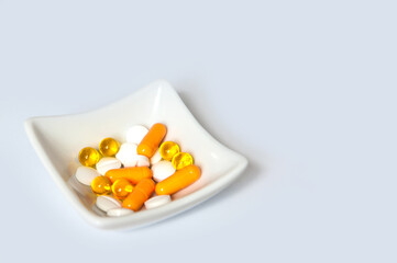 Fototapeta na wymiar Yellow and white pills tablets in white plate.