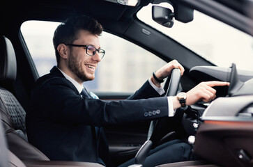 Man In Glasses Sitting In New Auto Checking Dashboard