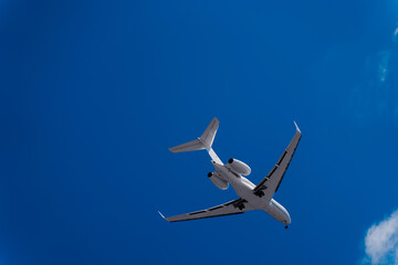 Flying plane against the blue sky. A white plane and an Indigo sky. Airliner before landing