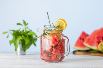 Detox water with watermelon, mint and lemon on white wooden background. Summer fresh drink.