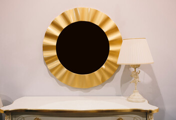Golden round frame mirror on the white wall and white lamp