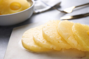 Delicious canned pineapple rings on marble board, closeup