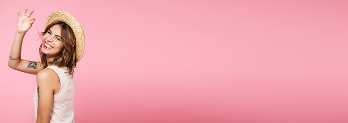 Portrait of a girl in summer hat looking at camera