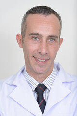 Portrait of mature handsome man doctor against white background
