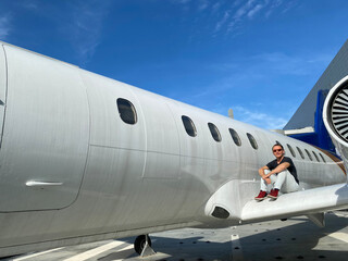 Obraz premium A man near a white plane. Blue sky. Journeys.