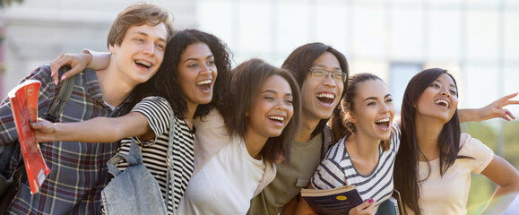 Multiethnic group of young happy students standing outdoors