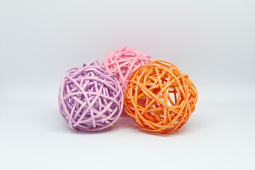 Dry reeds designed into three pink orange and lilac balls for decoration on white background.
