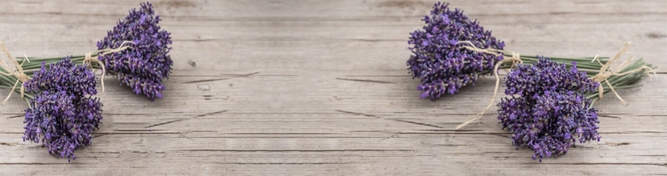 Many bouguet of violet purple lavendula lavender flowers herbs on old rustic wooden table, wood background banner panoramic panorama long, close up
