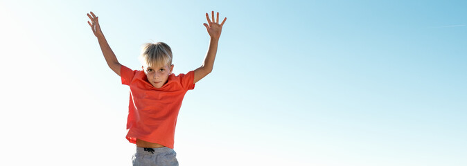 Playful Boy jumping outdoor. Copy space