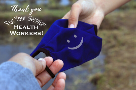 Thank You Card Greeting With Text Message For Heath Workers For Their Service. With Happy Smile Sign On Blue Clothe Face Mask In Young Man Woman Hands. Thank You For Your Service Health Workers.