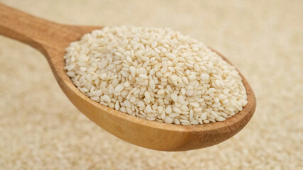 sesame seeds in wooden spoon and on background. top view