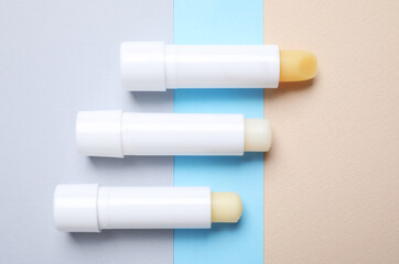 Hygienic lipsticks on color background, flat lay