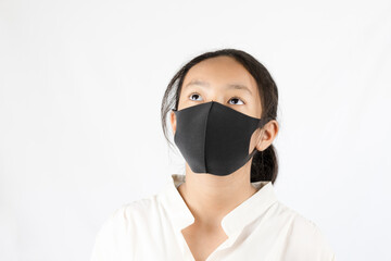 Portrait of Asian girl wearing a black mask on white background
