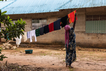 Local woman puting clothes to dry in local house of Zanzibar, Tanzania.