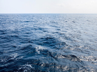 Vast ocean view with deep blue waters meeting the horizon, a serene and tranquil seascape.