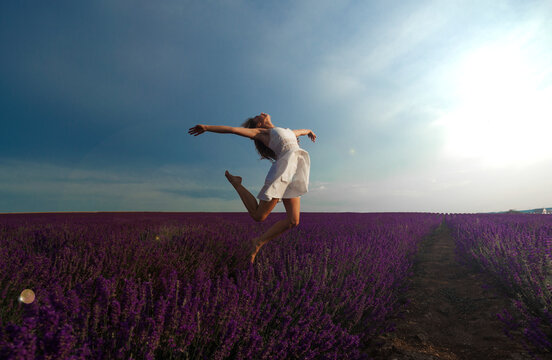 Happy Young Woman Jumping In The Field