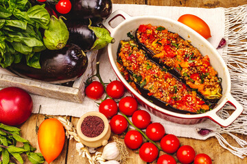 Karniyarik traditional Turkish food from stuffed eggplants with minced meat, tomato, greens and sesame seeds