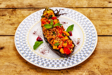 Karniyarik traditional Turkish food from stuffed eggplants with minced meat, tomato, greens and sesame seeds